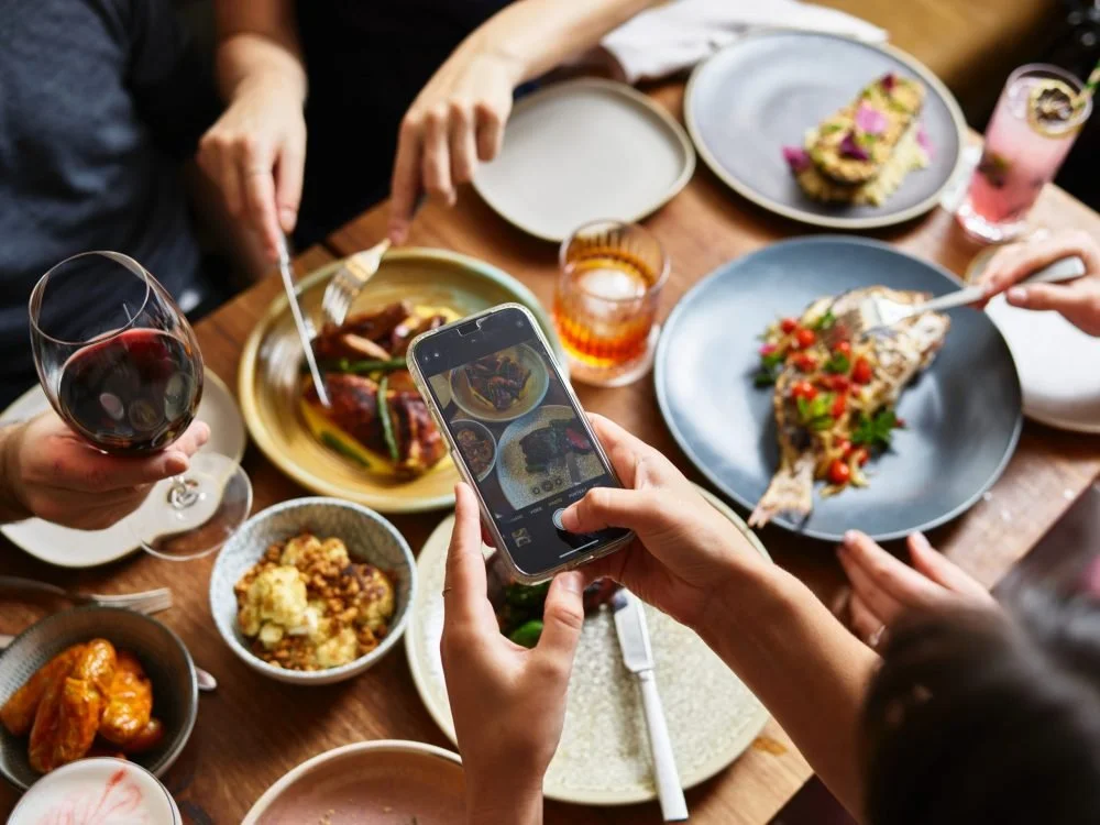 A diner photographing a dish at a restaurant